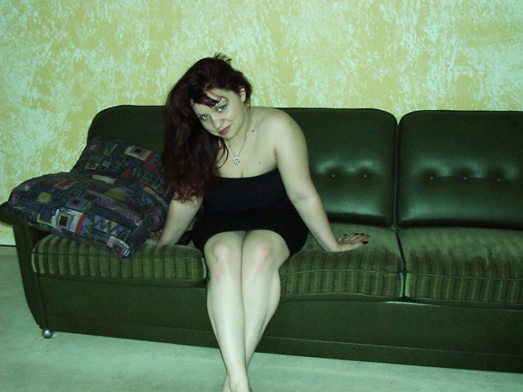 pummeliges Girl sitzt im Minirock auf der Couch